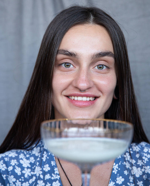 Smiling white european woman with a glass portrait isolated on dark grey - Foto, afbeelding