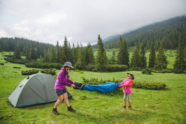 Mother and daughter having fun near their tent in the mountains  - Foto, Imagem