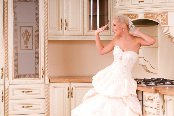 Braut steht in der Küche und lacht - Foto, Bild
