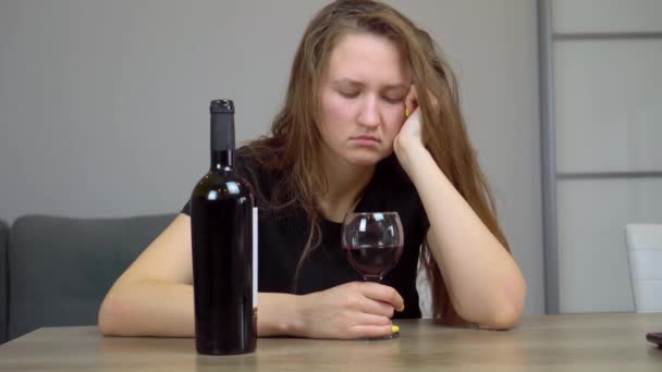 femme est triste et dévastée alcoolique assis à la maison sur le canapé boire du vin rouge - Séquence, vidéo