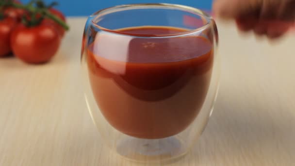 Beber paja de un vaso de jugo de tomate. Un vaso de jugo de tomate fresco de cerca. Jugo casero en la mesa. Bebida orgánica de vitaminas. - Imágenes, Vídeo