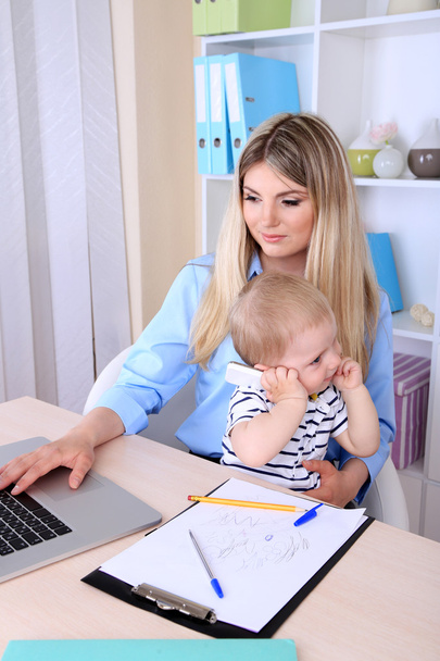 Pretty woman with baby working at home - Foto, immagini