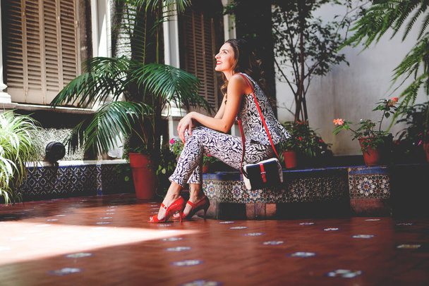 Krásná mladá žena sedí s červenými botami - Fotografie, Obrázek