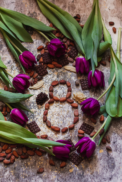 8 mars, journée internationale de la femme, huit à partir de fèves de cacao avec des tulipes violettes et des chocolats faits main autour. - Photo, image