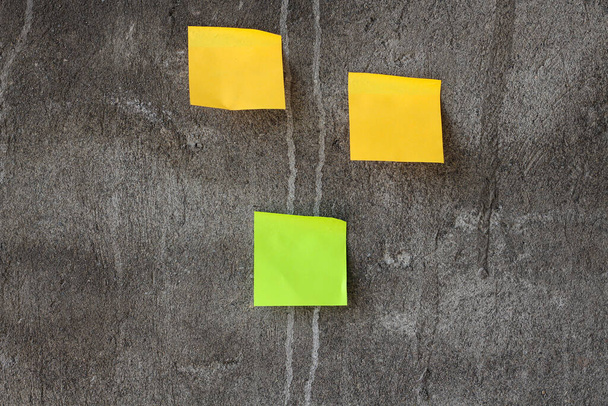 Yellow and green sticky notes on the gray wall - Photo, Image