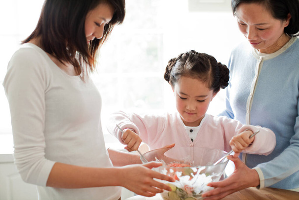happy family with daughter preparing food in kitchen - 写真・画像