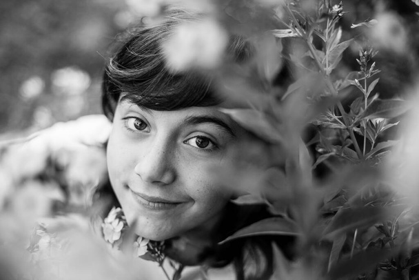 Portret nastolatki w sadzie, czarno-białe zdjęcie. - Zdjęcie, obraz