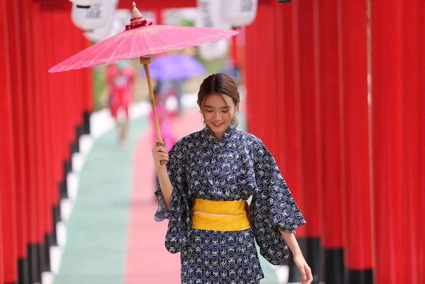  женщина в кимоно входит в святилище, в японском саду. - Фото, изображение