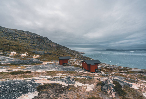 Panoramic image of Camp Eqi at Eqip Sermia Glacier in Greenland. nature landscape with lodge cabins. Midnight sun and pink sky. Tourist destination Eqi glacier in West Greenland AKA Ilulissat and - Photo, image