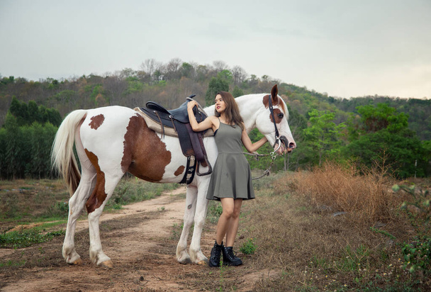 Nainen, jolla on hevonen kentällä - Valokuva, kuva