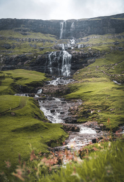 Waterfalls in the village of Saksun on the Faroe islands. No people around, traditional stone houses. - 写真・画像