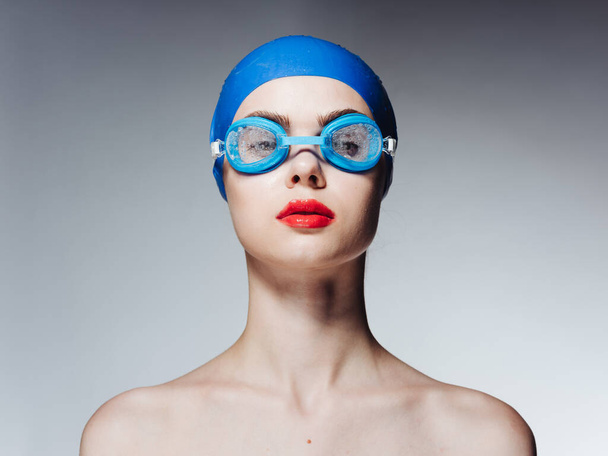 Mulher em óculos e em um azul natação boné atleta modelo de atletismo ombros nus - Foto, Imagem