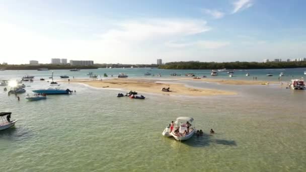 Ruch kamery lotniczej w lewo i w prawo Miami Beach sandbar Haulover people and boats in the middle of the bay - Materiał filmowy, wideo