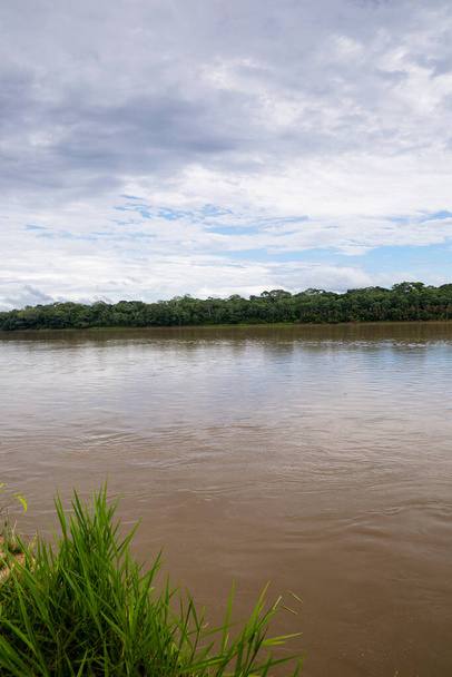 ペルーのジャングルの中の川のイメージ。雲と日中のアマゾンの森。川の中を旅するオープン自然. - 写真・画像