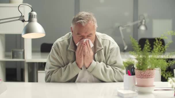 Ein grimmiger Büroangestellter pustet in die Nase und hustet in eine Serviette oder ein Taschentuch - Filmmaterial, Video