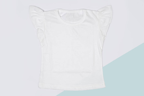 Dětské tričko je čistě bílé. Vyrobeno z měkké bavlněné tkaniny dodává komfort při použití. Vhodné pro každodenní nošení nebo oblečení při cestování. Bílá barva na tričku zvyšuje elegantní dojem. - Fotografie, Obrázek