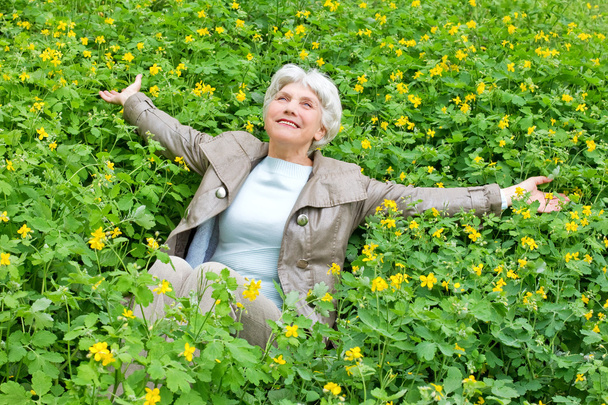 Feliz hermosa anciana sentada brazos extendidos en un gla
 - Foto, Imagen