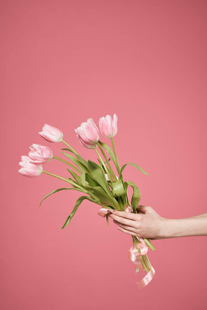 Bir buket çiçek ellerinde pembe arka plan hediye günü - Fotoğraf, Görsel