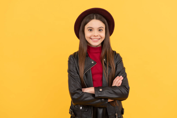 Ευτυχισμένο κορίτσι έφηβος σε καπέλο και δερμάτινο μπουφάν, μόδα. - Φωτογραφία, εικόνα