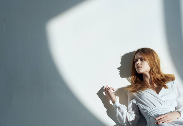 Frau Modell lehnt an der Wand ein fallender Schatten eines weißen Kleiderschranks - Foto, Bild