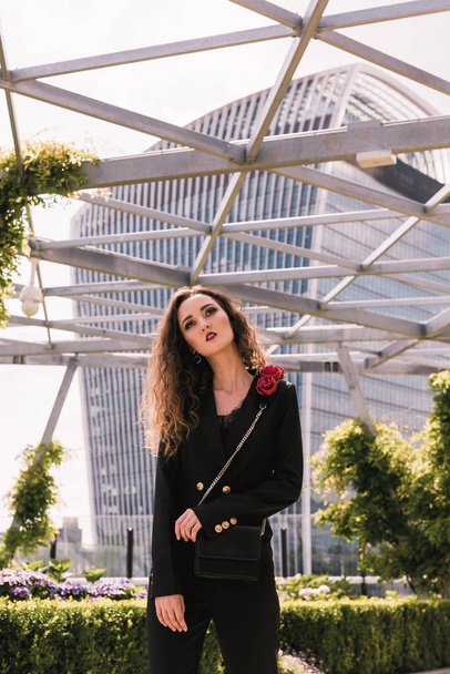 Portrait of stylish business lady in a classic black suit. Beauty. Background glass buildings. Sky terrace. Skyscrapers. - Photo, Image