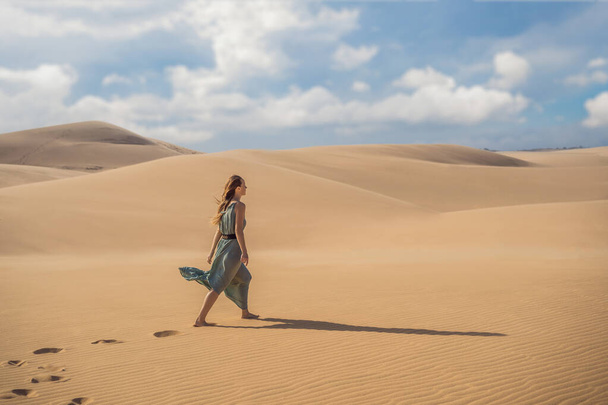 Young beautiful woman traveling in the desert. Sandy dunes and blue sky on sunny summer day. Travel, adventure, freedom concept. Tourism reopens after quarantine COVID 19 - Foto, Bild