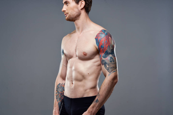 Sportlicher Mann mit aufgepumptem Presse-Tattoo auf den Armen Macho-Ausschnitt - Foto, Bild