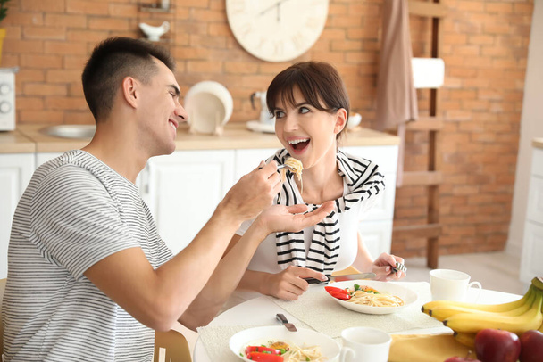 Feliz pareja joven almorzando en la cocina - Foto, Imagen