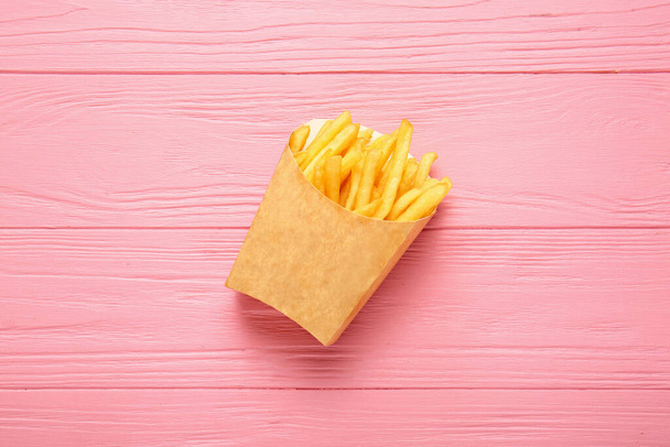 Бумажная коробка с вкусной картошкой фри на столе - Фото, изображение
