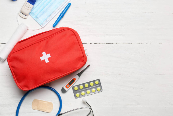 First aid kit on white wooden background - Zdjęcie, obraz