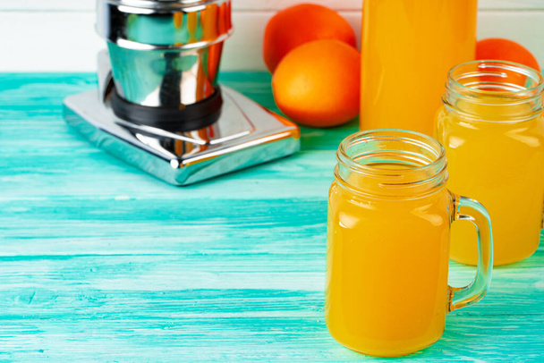 Glass with orange juice on green wooden table - Foto, Bild