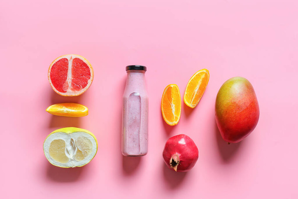 Botella de sabroso batido con frutas sobre fondo de color - Foto, Imagen