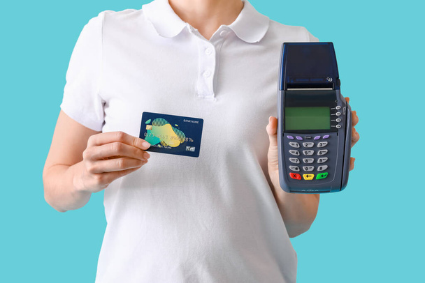 Жіночий кур'єр з платіжним терміналом і кредитною карткою на кольоровому фоні, крупним планом
 - Фото, зображення