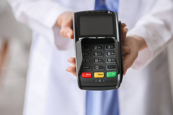 Doctor with payment terminal in clinic, closeup - Photo, Image