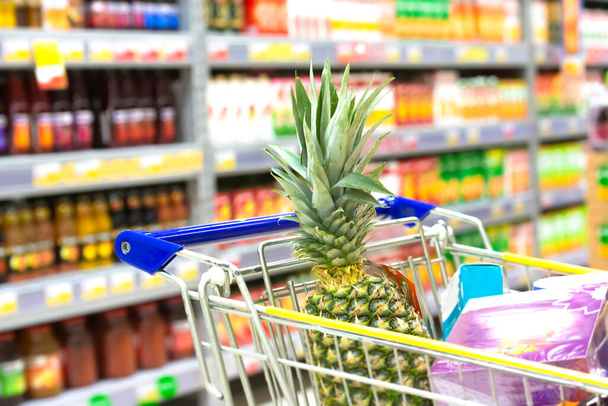 Gıda ürünleriyle dolu renkli bir süpermarkette alışveriş arabasının parçası. - Fotoğraf, Görsel