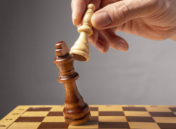 Business strategy concept. Knight making final last step to make checkmate in chess, falling king - Фото, зображення