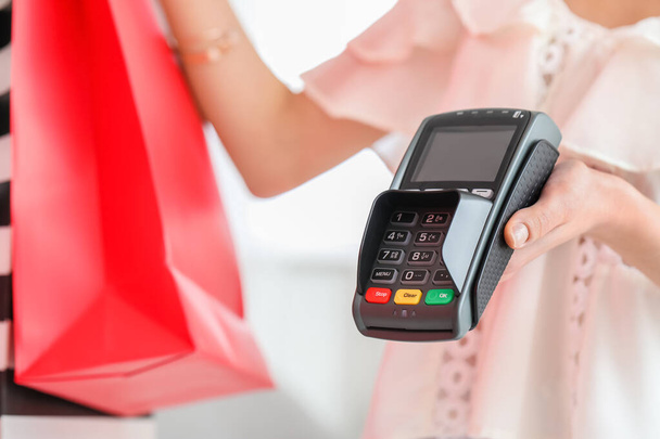 Young woman with payment terminal in modern shop, closeup - Photo, Image
