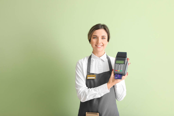 Waiter with payment terminal on color background - Φωτογραφία, εικόνα