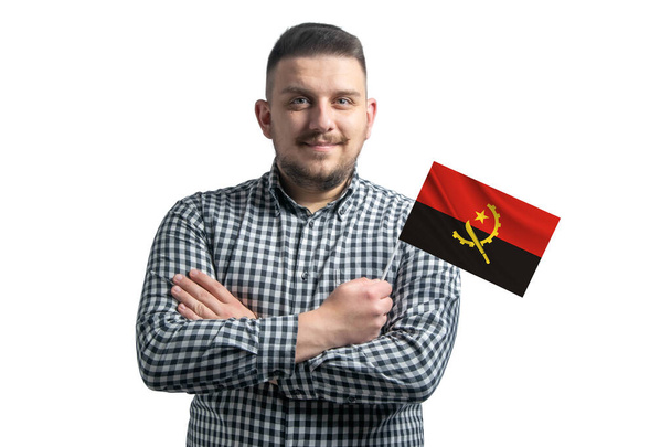 White guy holding a flag of Angola smiling confident with crossed arms isolated on a white background. - Foto, immagini