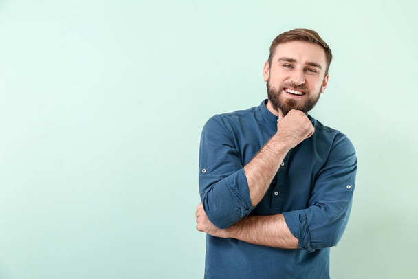 Handsome smiling young man on color background - Photo, Image