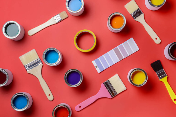 Банки фарб, зразки палітри та пензлі на кольоровому фоні
 - Фото, зображення