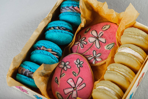 Sweet, tasty and colored - blue and yellow french macarons on a light background. The dessert is sweet. Selective focus. - Zdjęcie, obraz