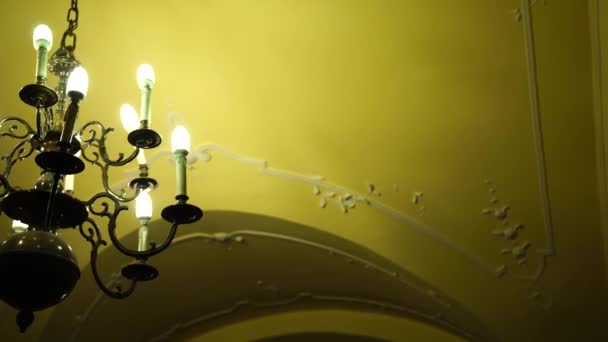 Черная металлическая люстра в стиле барокко с потолком и лампочками зажигания. - Кадры, видео