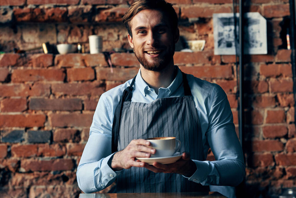 male waiter wearing apron coffee cup service lifestyle - Foto, Imagen