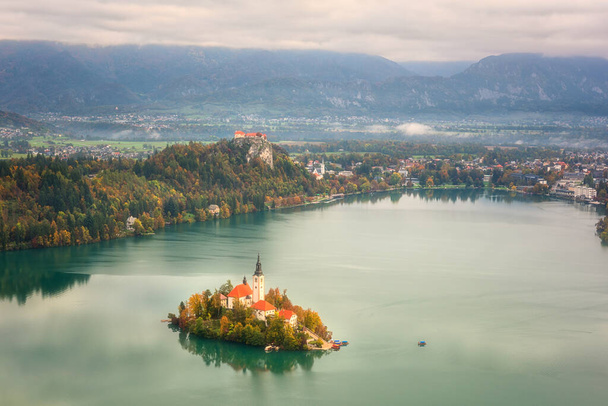 スロベニアの有名な高山湖(Blejsko jzero) 、素晴らしい秋の風景。小値賀からの湖、教会のある島、城とジュリアンアルプスの景色、屋外旅行の背景 - 写真・画像