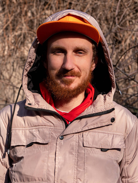 Bearded hipster guy millennial in orange snapback on nature background spring sunny day. Funny red beard emotional expressions male smiling face.Authentic mature man outdoor leisure Autumn fun walking - Photo, Image