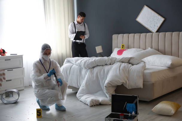 Investigators working at crime scene in messy room - Foto, imagen