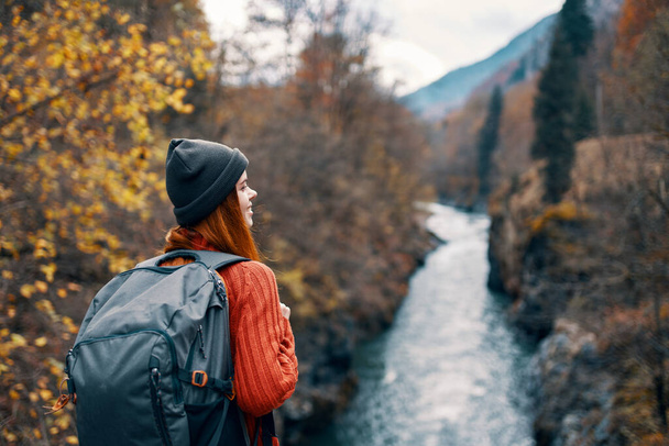 mujer excursionista con mochila en su espalda cerca del río de montaña en la naturaleza - Foto, imagen