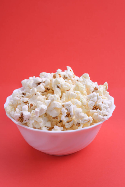 Popcorn in bowl on a red background. Close up. Top view. - Photo, Image