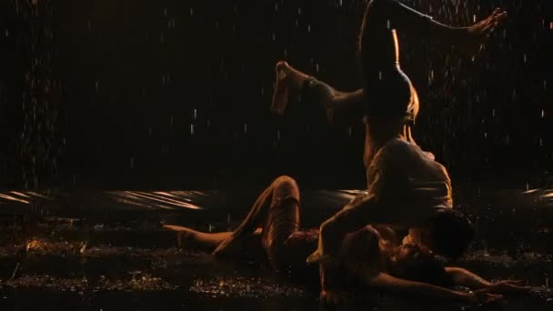 Sexy couple lies on surface of water in studio. Lovers kiss and erotically caress each other. Their naked bodies are covered with shiny water droplets. Close up. Slow motion - Video